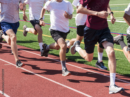 Boys running fast on a track in a group training run