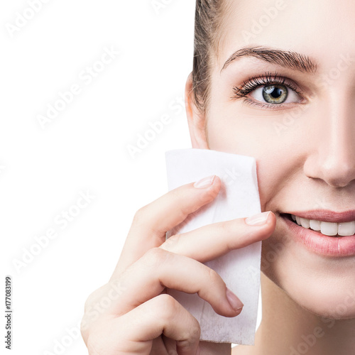 Young woman cleaning her face by napkins.