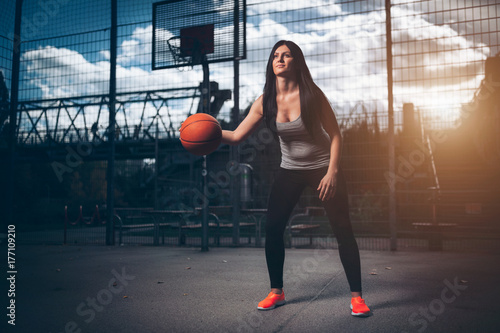 Female basketball player training outdoors on a local court