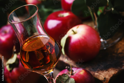 French strong golden alcoholic drink from apples, vintage wooden background, selective focus