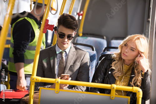 couple with smartphone in bus