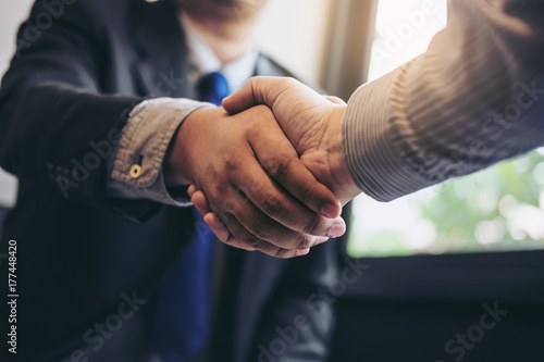 Two business men shaking hands during a meeting to sign agreement and become a business partner, enterprises, companies, confident, success dealing, contract between their firms