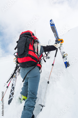 Skiiers climbing a steep slope.