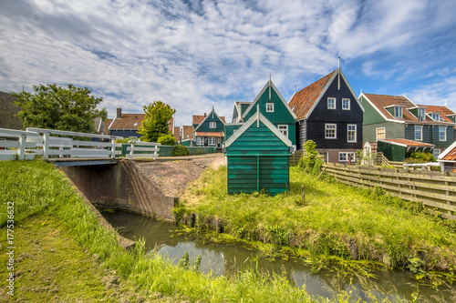 Characteristic Dutch village scene with wooden houses and bridge over canal