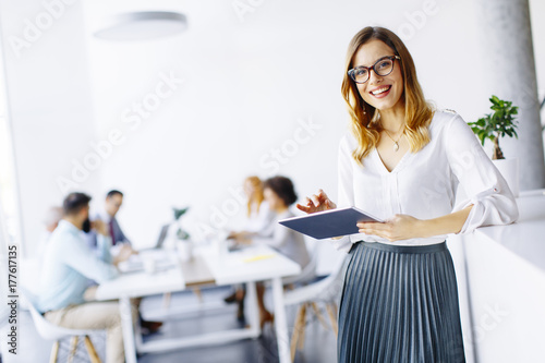 Elegant businesswoman standing in office with digital tablet