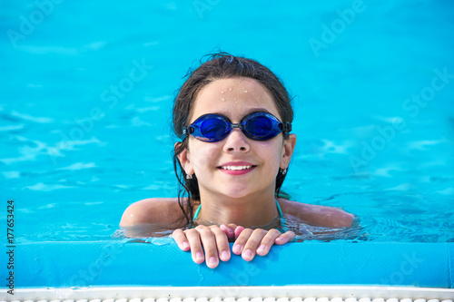 Swimmer schoolgirl in swimming pool portrait