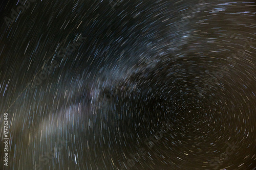 The movement of the stars and the milky way in the night sky around the North star. Night photography.