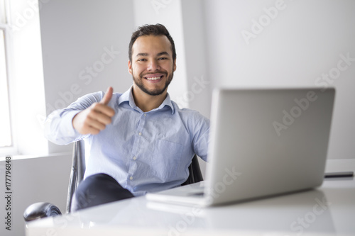 mexican attractive businessman on his 30s working at modern home office with computer laptop