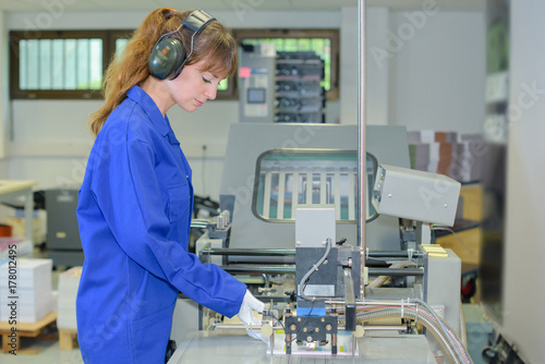Woman working on industrial machine