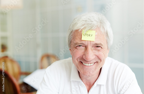 Grey-haired man with notepaper on his forehead should explain or guess the word