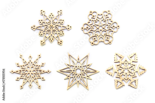 Laser cut wood snowflakes ornaments isolated on white background. Set of five different wooden snowflakes.