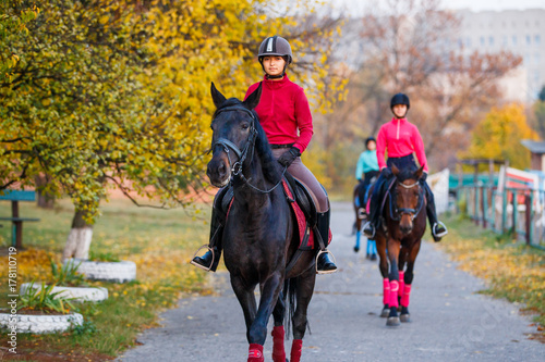 Grupa nastoletnich dziewczyn jedzie konie w jesień parku. Sport jeździecki tło z kopii przestrzenią