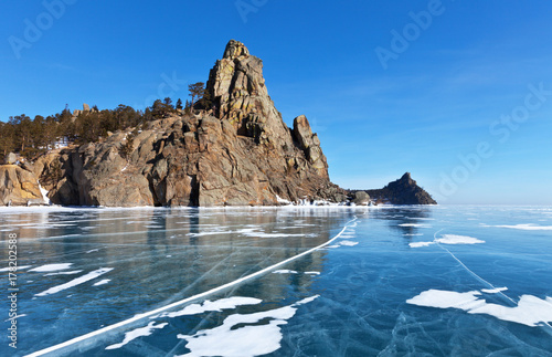 Winter landscape of the frozen Lake Baikal. View of the Rock Belfry (Kolokolnia) and Sandy Bay (Peschanaya) from the beautiful blue ice on a sunny day