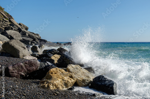 Rocky coast with splashing wave in Cinque Terre, Italy