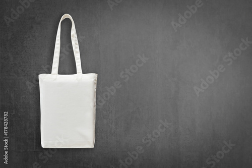 Eco cotton tote bag mock up white shopping fabric cloth sack with handle on blackboard background for mockup design backdrop template and go green concept