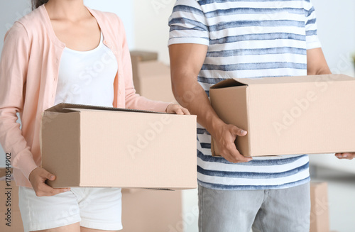 Young couple with moving boxes in their new apartment, closeup