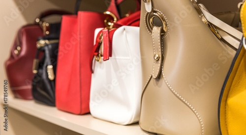 collection of handbags in female walkin closet