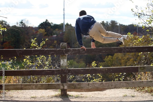 Delinquent teenager jumping a fence to trespass