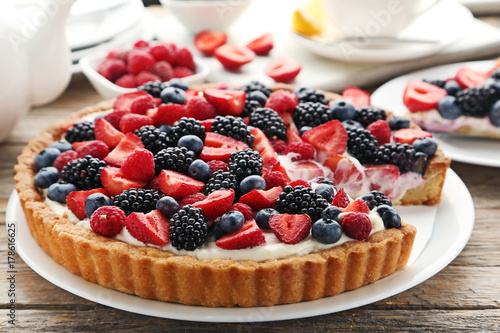 Sweet tart with berries on grey wooden table