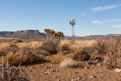 South African landscape with windpump and flat topped Karoo hills. Hot and sunny.