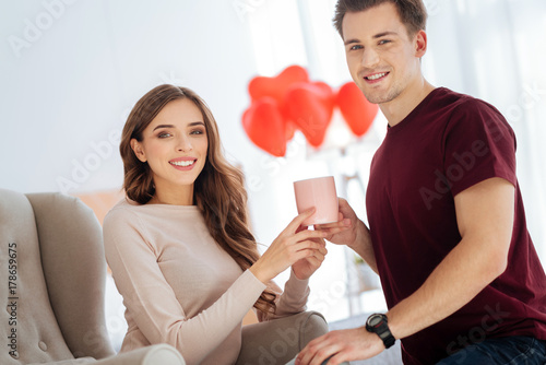 Beaming couple smiling while warming up with aromatic tea