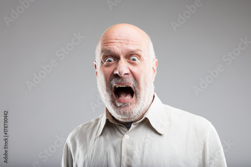 strong exaggerated fear expression of an old man