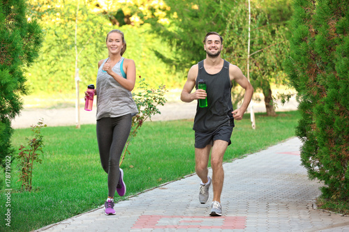 Young man and woman running in park