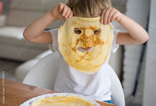 Little boy with a pancake instead of a mask on the face