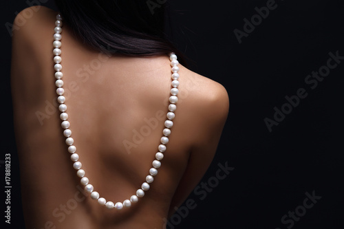 Portrait of beautiful nude long straight black hair woman with pearl necklace