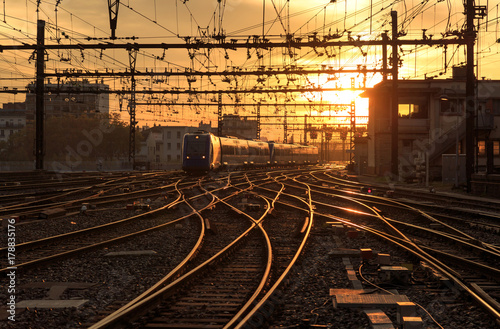 A train on the railroad tracks during a beautiful sunrise. Lyon, France.