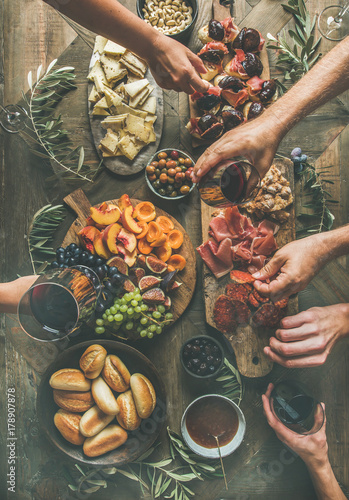 Overhead view of friends hands eating and drinking together