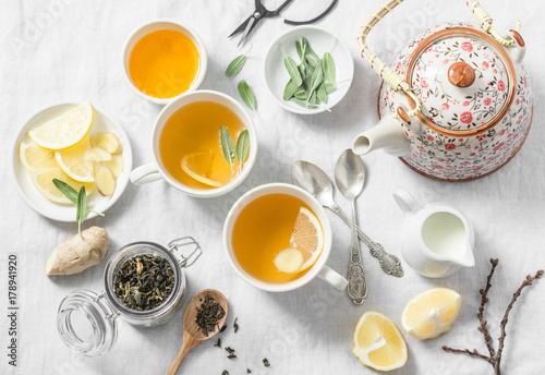 Green tea with lemon, ginger, sage on a light background, top view. Healthy detox drink. Tea ceremony