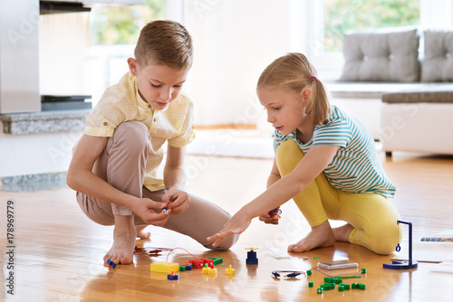 Two curious happy children playing with game