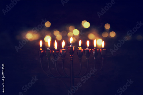 Low key image of jewish holiday Hanukkah background with menorah (traditional candelabra) and burning candles