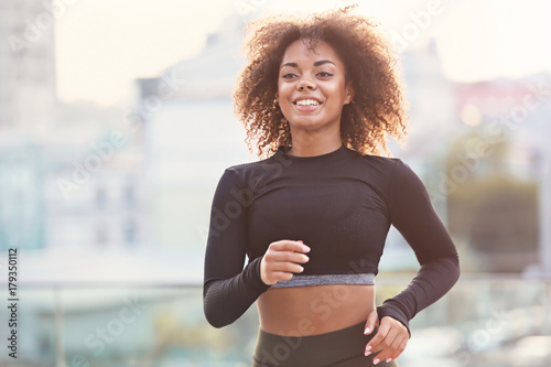 Sporty African American woman running outdoors