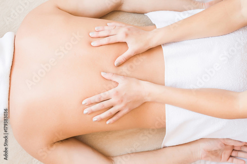 Woman masseur hands doing massage on young man back in the spa beauty salon. Enjoying life. Relaxing day. Body care concept.