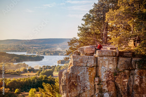Man sitting on rock outcrop at Gibraltar Rock, Wisconsin.