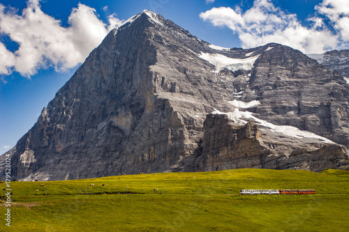 Majestic north face of Eiger mountain (3.967m - 13.015ft) and train to Jungfraujoch in the Bernese Alps in summer. Kleine Scheidegg, Bernese Oberland, Switzerland.