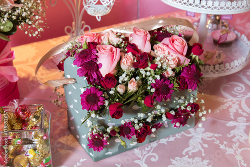 Gift box with colorful roses. Four-cornered birthday flower bouquet. Bouquets of paper flowers in a cardboard square boxes
