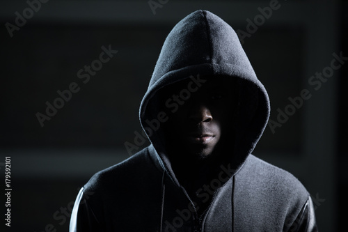 Mysterious african man with hood in darkness