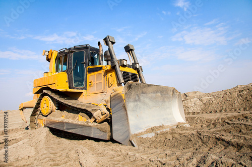 The bulldozer works on a sandy quarry.