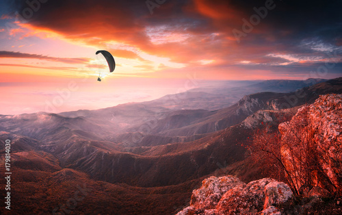 Paraglider silhouette in a light of majestic sunrise