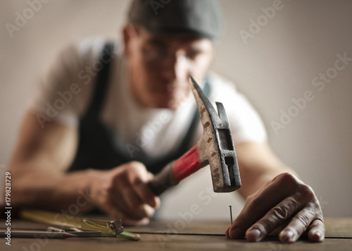 Carpenter hammering a nail