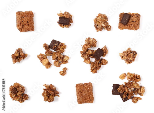 Crunchy granola, muesli pile with chocolate isolated on white background, top view