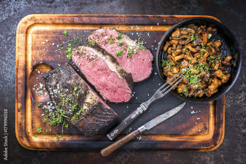 Barbecue wagyu roast beef with chanterelle as top view on a cutting board