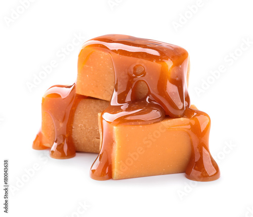 Sweet candies with caramel topping on white background