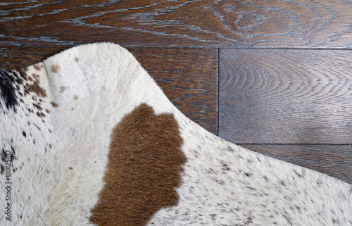 Zebu silver cowhide leather and hair details with brown engineered hardwood floor