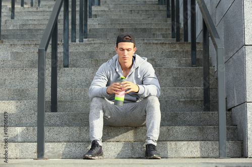 Sporty young man with protein shake, outdoors