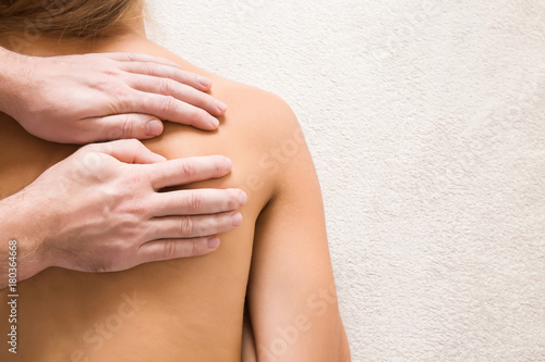 Masseur hands doing massage on young woman back in the spa beauty salon. Enjoying life. Relaxing day. Body care concept. Empty place for a text.