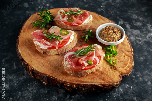Proaciutto ham, Italian bruschetta appetizers with soft chees, onions, whole grain mustard, chillies and fresh rosmary.